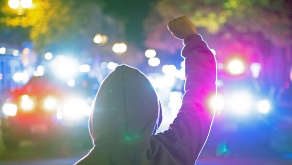 A woman holds up her fist as police declare an unlawful assembly after a vigil and march marking the shooting death by police of Black man Kevin E. Peterson Jr. in Vancouver, Washington - Sputnik International