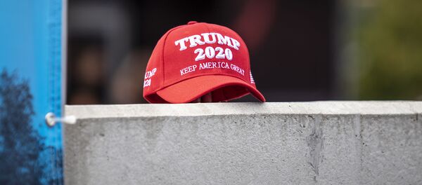 A supporter of President Trump set down a hat supporting his reelection during a speech by Democratic presidential candidate U.S. Sen. Kirsten Gillibrand (D-NY) at the Iowa State Fair on August 10, 2019 in Des Moines, Iowa. - Sputnik International