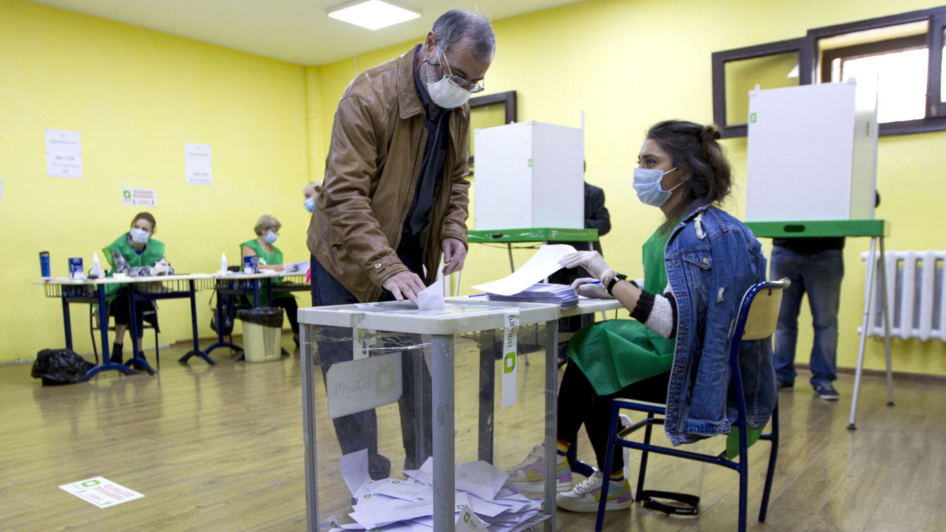 A man wearing a face mask to help curb the spread of the coronavirus, casts his ballot at a polling station during the parliamentary elections in Tbilisi, Georgia, Saturday, Oct. 31, 2020. The hotly contested election between the Georgian Dream party, created by billionaire Bidzina Ivanishvili who made his fortune in Russia and has held a strong majority in parliament for eight years, and an alliance around the country's ex-President Mikheil Saakashvili, who is in self-imposed exile in Ukraine.  - Sputnik International, 1920, 02.10.2021