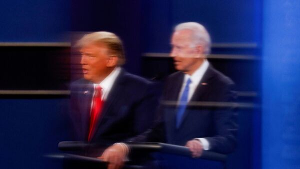 FILE PHOTO: U.S. President Donald Trump and Democratic presidential nominee Joe Biden are reflected in the plexiglass protecting a tv camera operator from covid as they participate in their second 2020 presidential campaign debate at Belmont University in Nashville, Tennessee, U.S., October 22, 2020 - Sputnik International