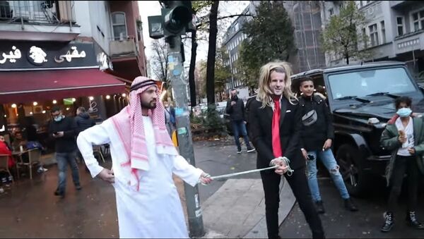 German YouTuber of Syrian origin, Fayez Kanfash, drags another person dressed as French President Emmanuel Macron through the streets of Berlin - Sputnik International