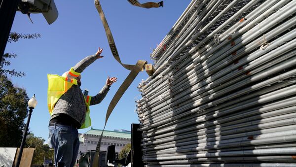 A workers works on a stack of fencing near a security checkpoint on the South side of the White House, the day before the U.S. presidential election, in Washington, U.S., November 2, 2020. - Sputnik International