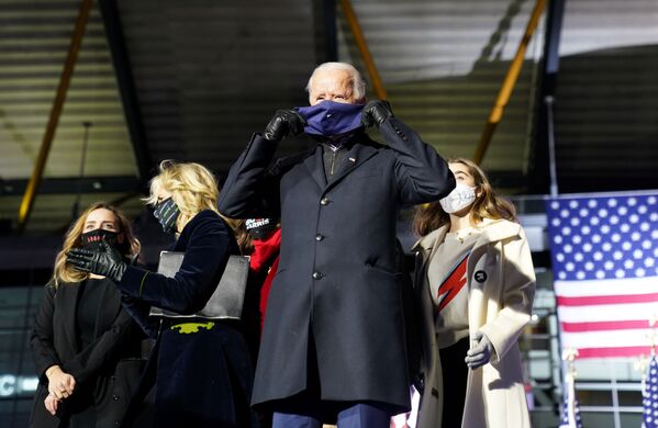 US presidential nominee for the Democrats and former Vice-President Joe Biden puts on a face mask while standing on stage with his family during a drive-in campaign rally at Heinz Field in Pittsburgh, Pennsylvania, US, 2 November 2020.  - Sputnik International