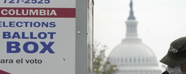 With the U.S. Capitol dome visible, a voter drops a ballot into an early voting drop box, Wednesday, Oct. 28, 2020, at Union Market in Washington - Sputnik International