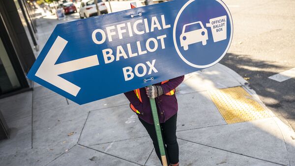 An election worker directs voters to a ballot drop off location on November 2, 2020 in Portland, Oregon. Oregons voting system allows for ballot processing before the start of Election Day.  - Sputnik International