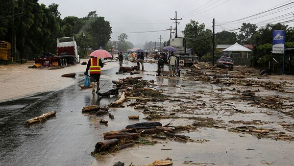 Residents walk along a road with debris dragged by a river during flooding caused by rains from Storm Eta, in Toyos, Honduras November 4, 2020 - Sputnik International