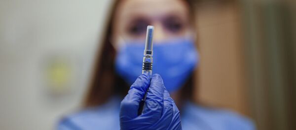 A health worker displays a dose of a COVID-19 vaccine currently on phase III clinical trials to be administered to Cem Gun, an Emergency Medicine Physician at the Acibadem Hospital in Istanbul, Friday, Oct. 9, 2020 - Sputnik International