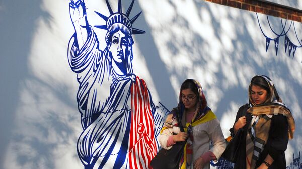 Women walk by mural on walls of former US Embassy compound in Tehran. File photo. - Sputnik International