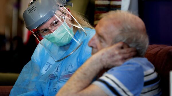 Elderly man at a care home with a nurse in full PPE - Sputnik International