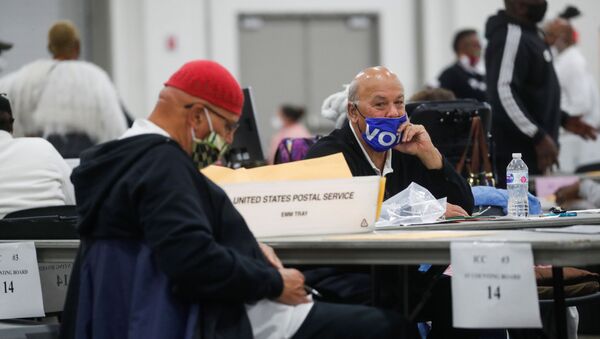 A man wearing a Vote mask looks on as votes continue to be counted at the TCF Center the day after the 2020 U.S. presidential election, in Detroit, Michigan, U.S., November 4, 2020. - Sputnik International