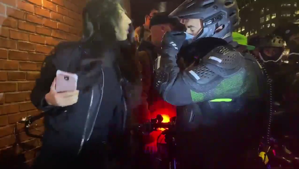 A screenshot from a video of a woman spitting in the face of a New York City Police Department sergeant on 4 November 2020 during a “Count Every Vote” protest in the West Village neighborhood of the borough of Manhattan, New York City, following the US 2020 presidential election. - Sputnik International