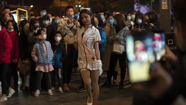 A young woman dressed as a nurse struts in a crowd gathered during Halloween night at a shopping district in Beijing on Saturday, 31 October 2020. Although Halloween is not traditionally celebrated in China, some residents in the Chinese capital took the time to dress up for a bit of fun.  - Sputnik International