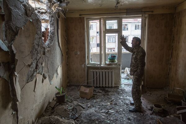 A man gestures while standing inside an apartment destroyed by shelling in Stepanakert, the capital of the unrecognised Nagorno-Karabakh republic. - Sputnik International