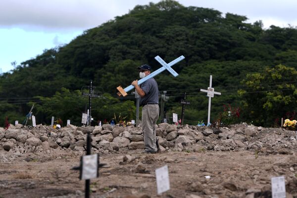 A man looks for the grave of a relative, victim of the new coronavirus pandemic, in the cemetery Covid-19, on the Day of the Dead, in Tegucigalpa, on 2 November 2020.  - Sputnik International