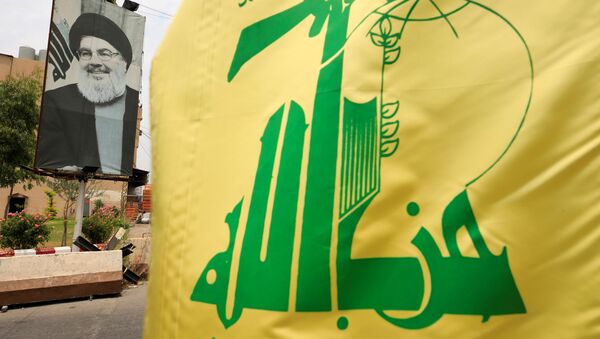 A Hezbollah flag and a poster depicting Lebanon's Hezbollah leader Sayyed Hassan Nasrallah are pictured along a street, near Sidon, Lebanon July 7, 2020.  - Sputnik International