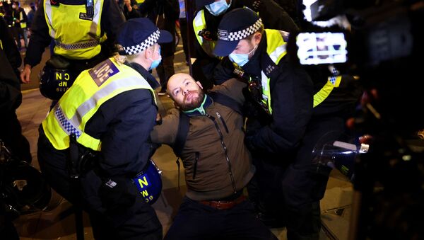 A man is detained by police officers as protestors from the Million Mask March and anti lockdown protesters demonstrate, amid the coronavirus (COVID-19) outbreak in London, Britain November 5, 2020. - Sputnik International