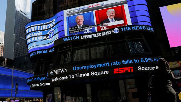 A person sleeps in front of a screen displaying election coverage in Times Square, Manhattan, New York City, U.S. November 6, 2020.  - Sputnik International