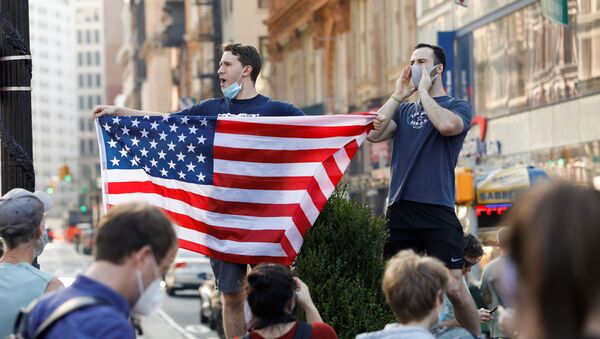 A man holds U.S. flag as people celebrate media announcing that Democratic U.S. presidential nominee Joe Biden has won the 2020 U.S. presidential election on Union Square in the Manhattan borough of New York City, U.S. - Sputnik International