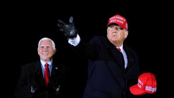 U.S. President Donald Trump hands out caps to supporters next to Vice President Mike Pence, as he holds a campaign rally at Gerald R. Ford International Airport in Grand Rapids, Michigan, U.S., November 2, 2020. REUTERS/Carlos Barria - Sputnik International