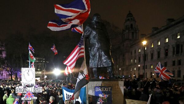 Brexit supporter wave Union flags as they wait near a statue of British war-time Prime Minister Winston Churchill, for the festivities to begin in Parliament Square, the venue for the Leave Means Leave Brexit Celebration in central London on January 31, 2020, the day that the UK formally leaves the European Union - Sputnik International