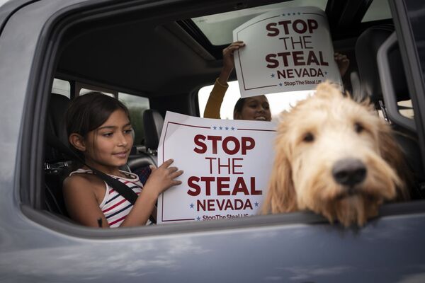 Supporters of President Donald Trump hold signs in a vehicle as people gather outside of the Clark County Elections Department in North Las Vegas, Nev. Saturday, Nov. 7, 2020 - Sputnik International