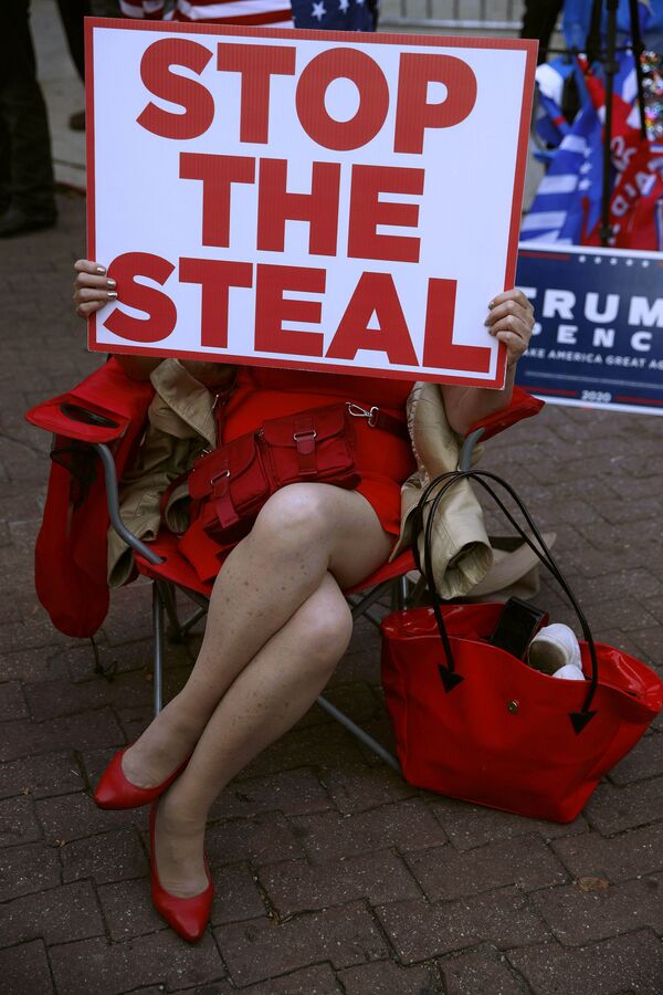 A demonstrator supporting President Donald Trump holds a sign that says, Stop the steal outside the Pennsylvania Convention Center where votes are being counted, Friday, Nov. 6, 2020, in Philadelphia - Sputnik International