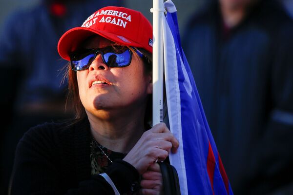 A supporter of US President Donald Trump listens to other supporters during a Stop the Steal protest after the 2020 US presidential election was called for former Vice President Joe Biden, in front of the Maricopa County Tabulation and Election Center (MCTEC), in Phoenix, Arizona, US, November 8, 2020 - Sputnik International
