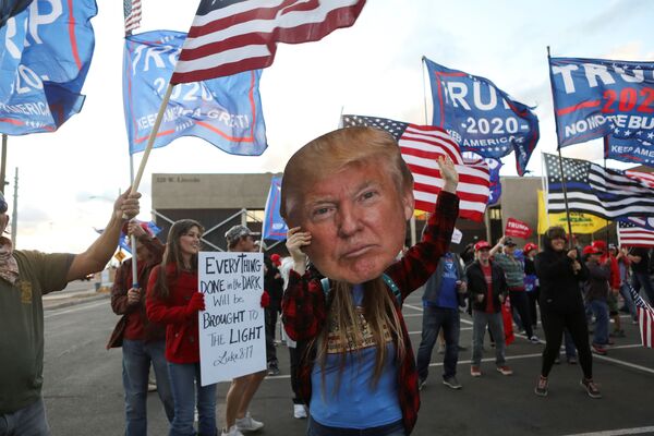 A woman holds a cutout of US President Donald Trump's head as supporters gather at a Stop the Steal protest after the 2020 US presidential election was called for former Vice President Joe Biden, in front of the Maricopa County Tabulation and Election Center (MCTEC), in Phoenix, Arizona, US, November 8, 2020 - Sputnik International