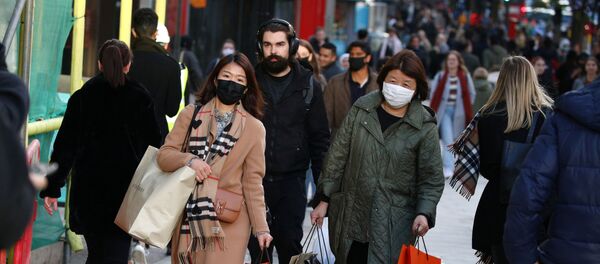 Shoppers wearing protective face masks walk on Oxford Street, after new nationwide restrictions were announced during the coronavirus disease (COVID-19) outbreak in London, Britain, November 4, 2020. - Sputnik International