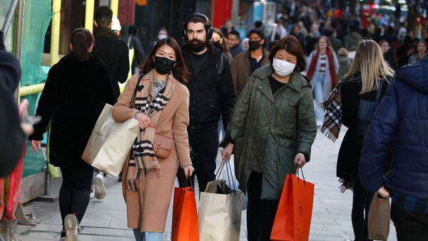 Shoppers wearing protective face masks walk on Oxford Street, after new nationwide restrictions were announced during the coronavirus disease (COVID-19) outbreak in London, Britain, November 4, 2020. - Sputnik International