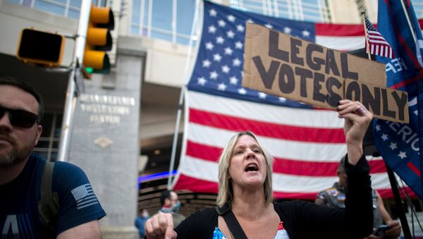 Carri Dusza, a supporter of President Donald Trump, holds a placard stating LEGAL VOTES ONLY while shouting across the street at supporters of President-elect Joe Biden the day after a presidential election victory was called for Biden, in Philadelphia, Pennsylvania, U.S. November 8, 2020.  - Sputnik International