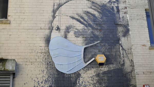 Banksy's Girl with a Pierced Eardrum mural has been given a face mask in a nod to the coronavirus pandemic as the UK continues in lockdown to help curb the spread of the coronavirus, in Bristol, England, Wednesday April 22, 2020 - Sputnik International