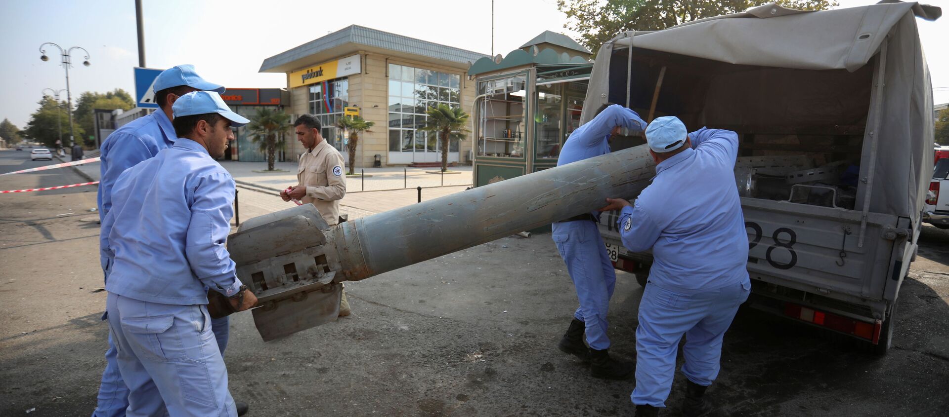 Azeri investigators load a fragment of an artillery shell in a street recently hit by shelling during a military conflict over the breakaway region of Nagorno-Karabakh, in the town of Barda, Azerbaijan October 29, 2020 - Sputnik International, 1920, 11.11.2020
