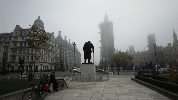 People sit talking near the statue of Winston Churchill and the scaffolded Houses of Parliament and the Elizabeth Tower, known as Big Ben, shrouded in fog, on the first day of Britain's second lockdown designed to save its health care system from being overwhelmed by people with coronavirus, in London, Thursday, Nov. 5, 2020 - Sputnik International