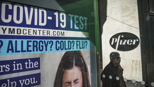 A bus stop ad for COVID-19 testing is shown outside Pfizer world headquarters in New York on Monday Nov. 9, 2020. Pfizer says an early peek at its vaccine data suggests the shots may be 90% effective at preventing COVID-19, but it doesn't mean a vaccine is imminent. - Sputnik International