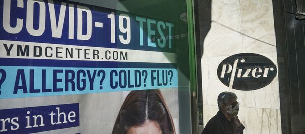 A bus stop ad for COVID-19 testing is shown outside Pfizer world headquarters in New York on Monday Nov. 9, 2020. Pfizer says an early peek at its vaccine data suggests the shots may be 90% effective at preventing COVID-19, but it doesn't mean a vaccine is imminent. - Sputnik International