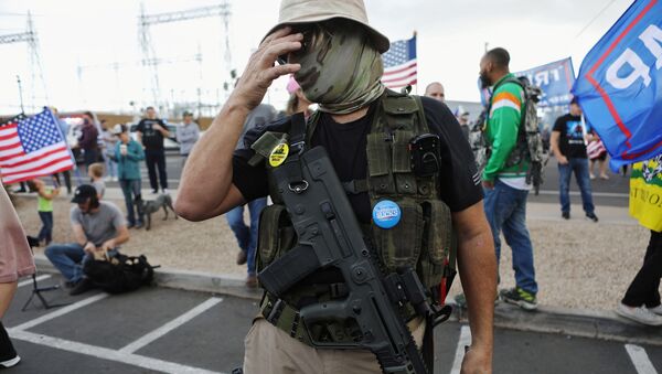 A Trump supporter carries a semi-automatic rifle at a Stop the Steal protest after the 2020 U.S. presidential election was called for Democratic candidate Joe Biden, in front of the Maricopa County Tabulation and Election Center (MCTEC), in Phoenix, Arizona, U.S., November 7, 2020 - Sputnik International