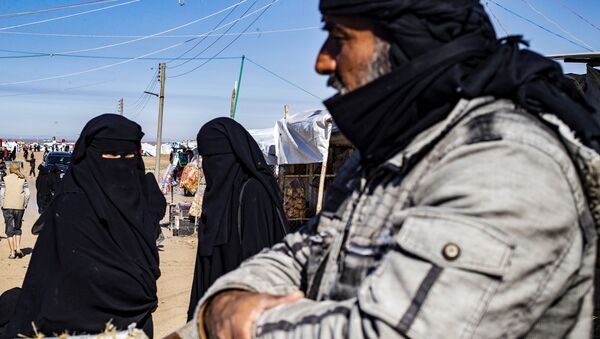 Two women chat as a man looks on at the Kurdish-run al-Hol camp in the al-Hasakeh governorate in northeastern Syria on January 25, 2020, where families of Islamic State (IS) foreign fighters are held - Sputnik International