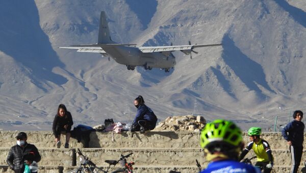 An Indian Air Force aircraft flies past cyclists near a mountain range in Leh, the joint capital of the union territory of Ladakh bordering China, on October 27, 2020 - Sputnik International