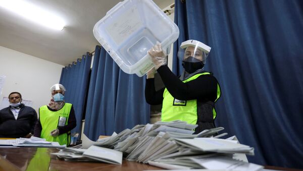 An election official wearing a protective mask empties a ballot box after parliamentary elections, amid fears over the rising number of the coronavirus (COVID-19) infections, in Amman, Jordan 10 November 2020.  - Sputnik International