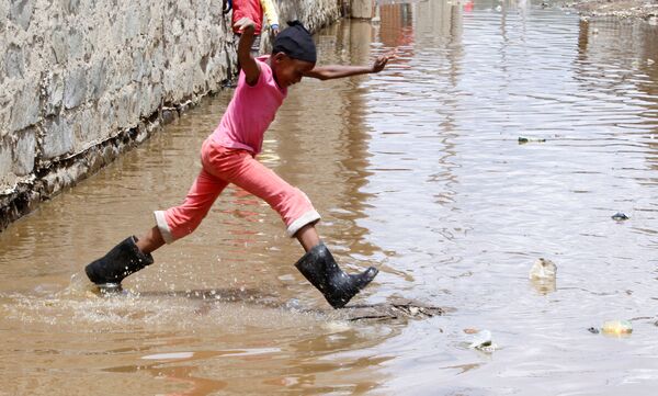 A child jumps as she wades through flood waters after the levels at Lake Naivasha swelled to a record high, pushing hundreds of people from surrounding farms around Naivasha town within Nakuru county, Kenya on 8 November 2020. - Sputnik International