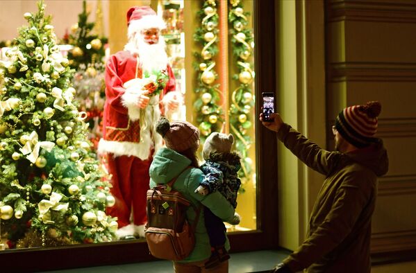 A passer-by takes a picture of Santa Claus in Nikolskaya Street in Moscow.  - Sputnik International