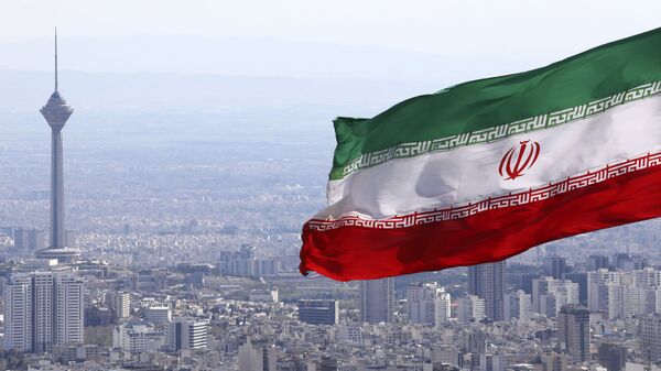  In this 31 March 2020, file photo, Iran's national flag waves as Milad telecommunications tower and buildings are seen in Tehran, Iran - Sputnik International