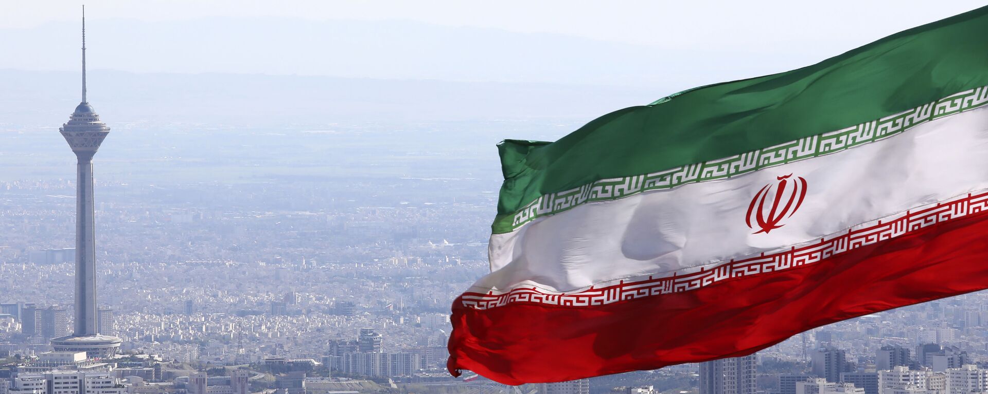  In this 31 March 2020, file photo, Iran's national flag waves as Milad telecommunications tower and buildings are seen in Tehran, Iran - Sputnik International, 1920, 06.03.2021