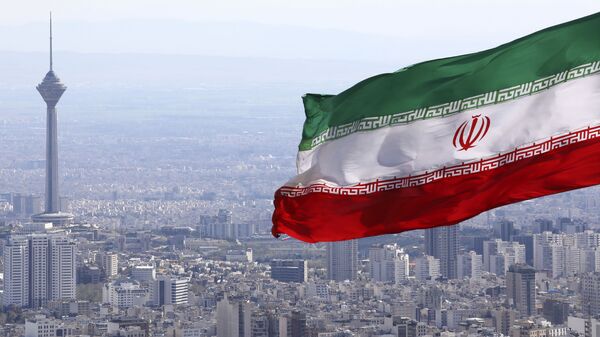  In this 31 March 2020 file photo, Iran's national flag waves with the Milad telecommunications tower in the background in Tehran, Iran - Sputnik International