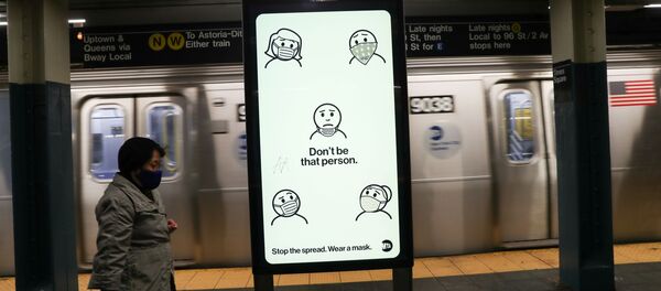 A subway rider wearing a mask passes a city-sponsored ad promoting face masks as a precautionary measure, as the global outbreak of the coronavirus disease (COVID-19) continues, in New York City, U.S., November 14, 2020. - Sputnik International