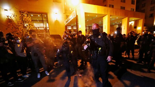 A Washington DC metropolitan police officer stomps out the fire and threatens to pepper spray the protesters after anti-fascist protesters burn a poster of U.S. President Donald Trump at the front door of the Capital Hilton hotel in downtown Washington, U.S. November 14, 2020. - Sputnik International