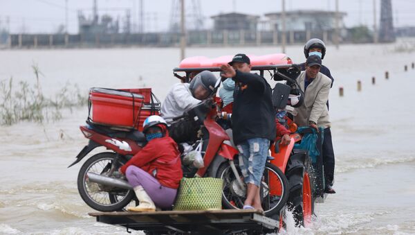 Residents are carried on a forklift truck to dry land through flood waters brought by heavy rain from Typhoon Vamco after it made landfall in Thua Thien Hue province on November 15, 2020.  - Sputnik International