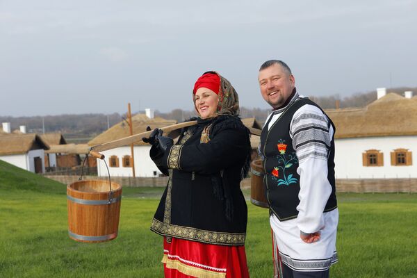 A woman and a man, both dressed in historical costumes, attend the opening of the Slobozhanschina ethno village in the Belgorod Region. - Sputnik International