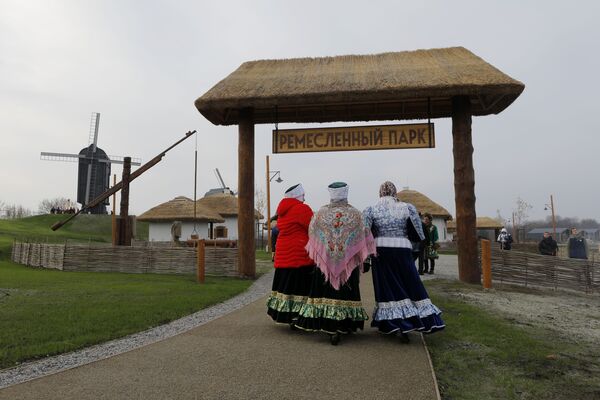 Women dressed in historical costumes walk around the premises of the newly-inaugurated ethno village Slobozhanschina in the Belgorod Region. - Sputnik International